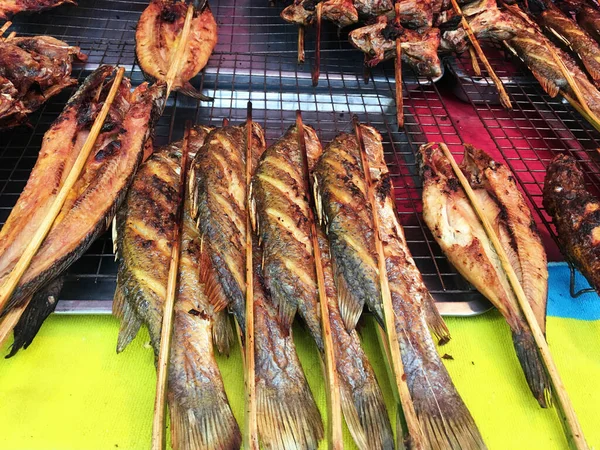 Grilled fish and meat skewers sold in an Asian food street market.