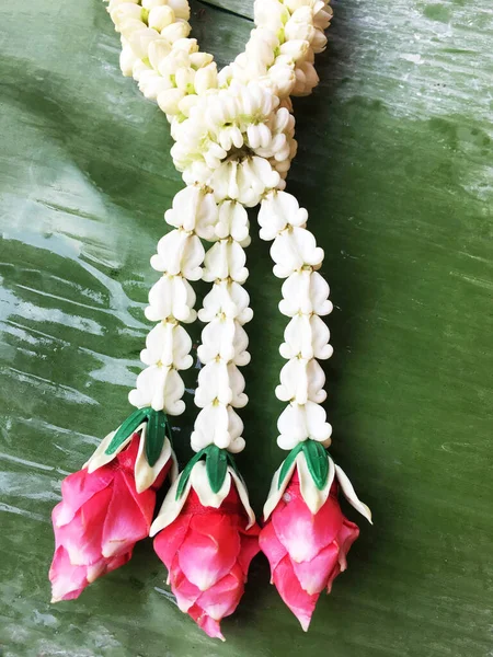 Garland of fresh flower with Jasmine and rose on banana leave.Garland of fresh flower with Jasmine and rose on banana leave.