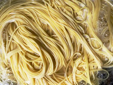 Top View Boiling Korean Instant Noodle or Spaghetti Pasta on Red Pan, Home Cooking Activity.