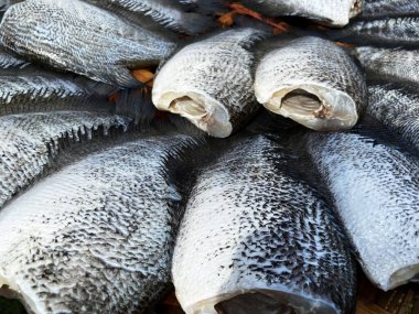 Kurutulmuş yılan derisi gourami satılık bir masaya konmuş. Tayland 'da popüler bir yiyecek koruma alanıdır..