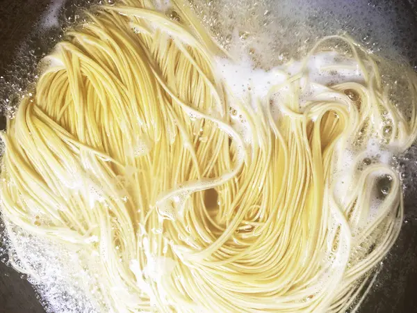 stock image Yellow white thin strands of noodles in bowl. Raw and uncooked. Cooking the noodles in boiling water and rinsing vermicelli or spaghetti with water