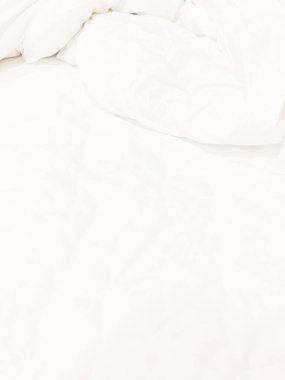 Yapılmamış yatak örtüsü veya beyaz kumaş kırışıklık dokusu arka planının üst görünümü.