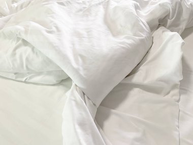 Yapılmamış yatak, kırışık yastık kılıfları, çarşaf ve yorgan..