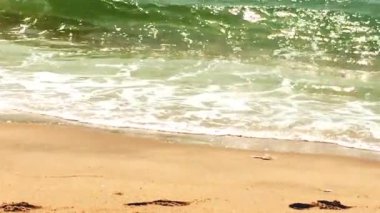 Deniz dalgaları kumlu sahile çarpıyor.