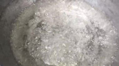 Kaynar suda su, kaynar suda yakın çekim, kaynayan suda kabarcıklar. Yavaş çekim seçici odak