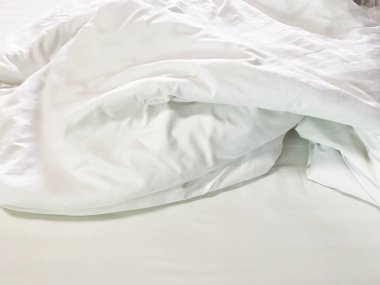 Yapılmamış yatak, kırışık yastık kılıfları, çarşaf ve yorgan..