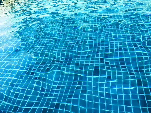 Yüzme havuzu dokusu ve yüzey suyu ya da arka planda güneş yansıması olan su...
