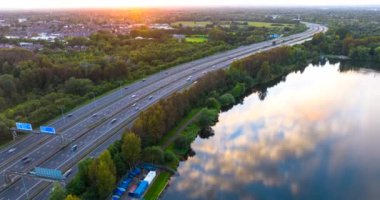 Güneş batarken Manchester Birleşik Krallık 'taki Lakeside otoyolunun havadan çekilmiş hızlandırılmış videosu..  