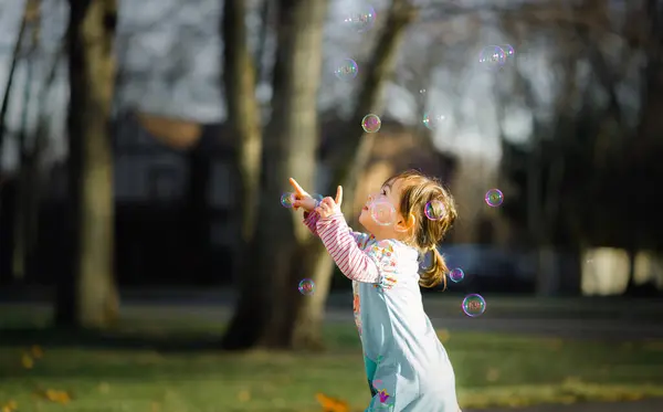 Toddler Girl Plays Colorful Bubbles Warm Sun Light — Stock Photo, Image