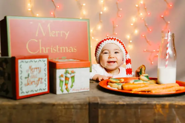 在礼物和礼物中等待有针织帽子的圣诞老人宝宝平安夜 — 图库照片
