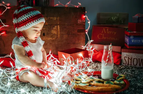 Child Festive Knit Hat Playing Christmas Lights Milk Cookies Carrot — Stock Photo, Image