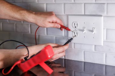 Elektrikçi çoklu metre ile elektrik prizini test ediyor