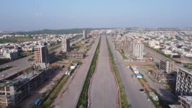 Düz yolu takip ettikçe, dinamik bir şehir manzarası ortaya çıkıyor. Gelişmekte olan yapılar, gelişmemiş bir plaza ve farklı yol işaretleri hepsi parlak ve umut verici bir geleceği işaret ediyor..