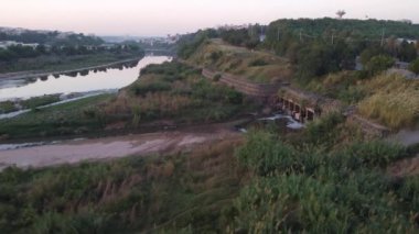 Trafik Kuğu Nehri 'nin her iki yakası boyunca sürekli akar, lağım suyu bulanık nehre karışır ve şehir manzarasında rahatsız edici bir kontrastlık yaratır. Rawalpindi Pakistan 24 Ekim 2024