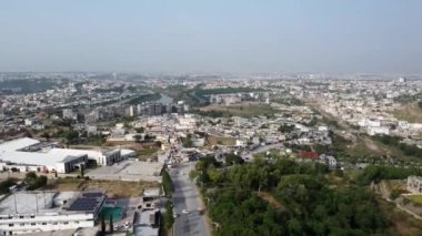 Gökdelenleri, işlek caddeleri ve yemyeşil parkları olan canlı bir şehrin insansız hava aracı görüntüsü. Şehir keşfi ve fotoğrafçılık için mükemmel. 10 30 2024 Rawalpindi Pakistan