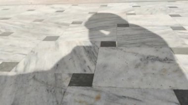 Adamın gölgesi elleriyle yüzünü temizliyor.