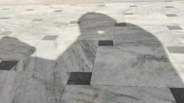 Adamın gölgesi elleriyle yüzünü temizliyor.