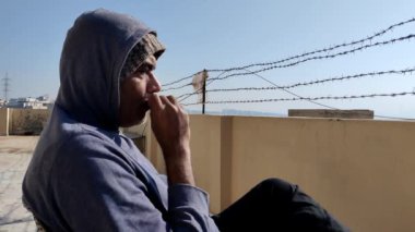 Güneşli bir kış gününde sigara içen ve düşünen adam