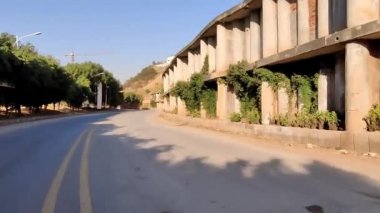 Kontrol paneli bakış açısı, Bahriye şehri Rawalpindi 'de sahil yolunda araba kullanmak. Torpido gözü asfalt yolda. Geniş açı, inşaat vinci çalışıyor.