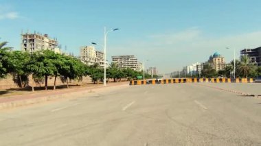 Güneşli bir kış gününde ana yolu kapatmak için beton levhalar yolda. Rüzgar esiyor ve inşaat halindeki bazı yapılar görülebiliyor.