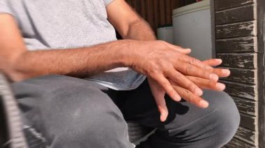Bir eli diğerinin üzerine sürten adam derin bir depresyonda.