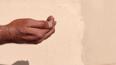 Elleri bağlılık içinde katlanmış dua eden Müslüman bir adamın pov çekimi. Duruşu derin inancı, tevazuyu ve maneviyatı yansıtıyor. Bu hareket, Tanrı 'yla olan bağlantıyı, iç huzuru ve samimi ibadeti simgeliyor..