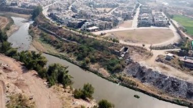 Gayri menkul kavramları: 4K Gökyüzü Altında Geniş Tarım Arazisi Olan Nehrin Yanındaki Bir Şehrin Havadan Görünümü