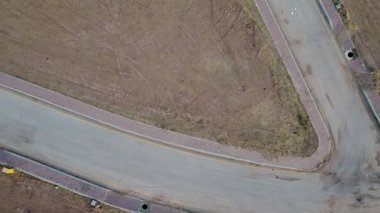 4K İHA, bir köşe arazisinin arazi araştırmasını yakalıyor, gayrimenkul kavramları sergiliyor..
