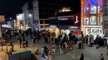 Alışveriş yaptıktan sonra sokakta yürüyen, meydandan çıkan ve alışveriş sonrası keyifli yürüyüşlerin tadını çıkaran insanlar, 23 Mart 2025, Rawalpindi Pakistan