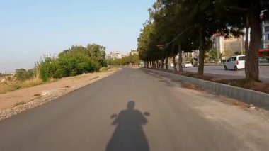 2 Nisan 2025 Rawalpindi Pakistan, Arkaplanda Trafik ve Binalarla Hizmet Yolundaki Motosiklet Sürücüsü Gölgesi