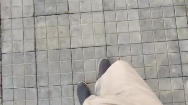 Rawalpindi Pakistan, 11 Nisan 2025 'te, bir günde kare bir fayans zemininde yürüyen ayaklar.