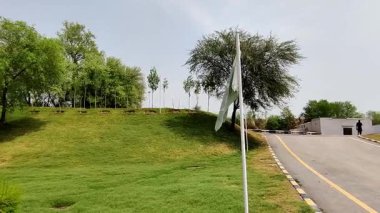 Pakistan bayrağı boş yolun yanındaki parkta.