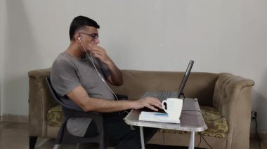 Terli Adam Evden Çalışırken Bilgisayarda Konuşurken Kulaklığı Ayarlıyor