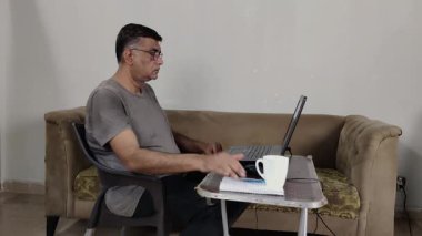 Uzaktan İşçi, Tea Cup 'ı pedlere koyup, Elleri Serbest Bıraktıktan sonra Oturuma Hazırlanıyor