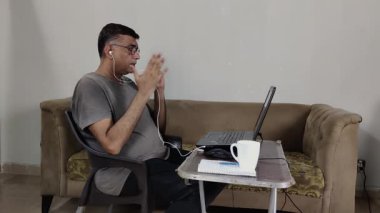 Çevrimiçi Toplantıda Katılan Adam Dizüstü bilgisayarla konuşurken El Hareketleriyle İfade Ediyor