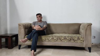 Adam koltukta hareketsiz oturuyor ama bir ayağını hafifçe vuruyor Derin Psikolojik Mücadele