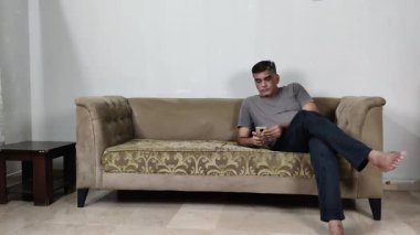 Düzensiz Duruşu Olan Adam Telefonunu Kaldırır ve Ekran Arasında Kaydırır Dikkatimi Veren Ya da Gelişigüzel Göz gezdirme