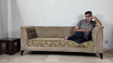 Adam usulca gülümser ve aniden telefonu kulağına kaldırır. Beklenmedik bir ses ya da mesaja yakından bakar.