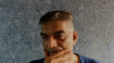 Mavi Arkaplan Karşısında Düşünceli Poz Verirken İnsanların Yüzündeki Ciddi İfade