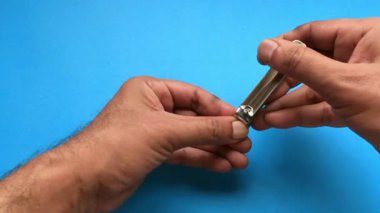 Hijyen Konsepti için Turkuaz Arkaplan 'da El Tırnak Kesme Makası Kullanılıyor