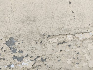 Yıpranmış bir duvarın üzerini boyayla ve altta görünür bir katmanla kapatın.