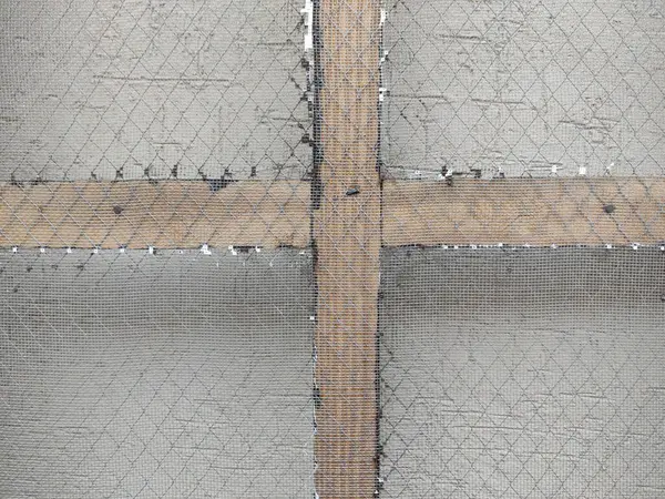 Gri yüzey üzerinde kahverengi haç şekilli tel örgülerin havadan görüntüsü