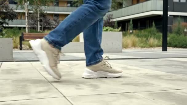 Vrouwen Benen Sneakers Jeans Lopen Langs Stoep Geplaveid Met Licht — Stockvideo