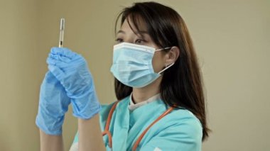 Aşı ve sağlık hizmeti konsepti. Asyalı kadın doktor, tıbbi maske takan hemşire ve aşı şırıngası tutan eldivenler. HD.