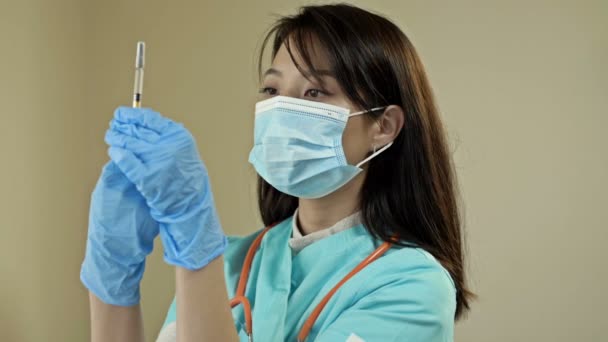 予防接種と医療の概念 アジアの女性医師 医療面マスクの看護師 ワクチンで注射器を保持手袋 — ストック動画