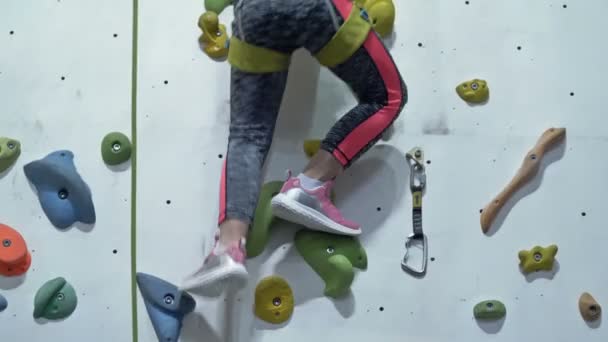 ピンクのスニーカーの女の子の足は ホールドにもたれて 登山壁を登る — ストック動画