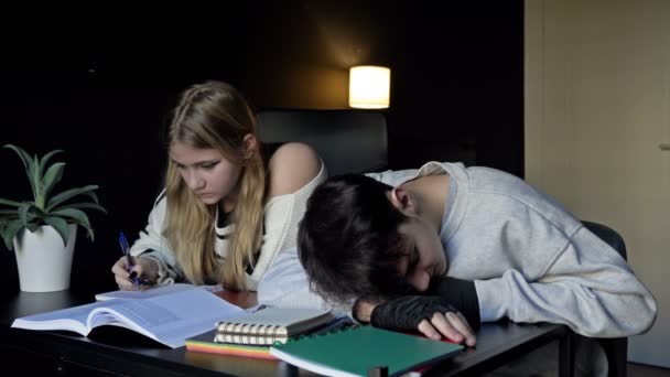 两个高中生 一个男生 一个女生 正在准备一起上大学 这个女孩叫醒了休眠的疲倦的男朋友 — 图库视频影像