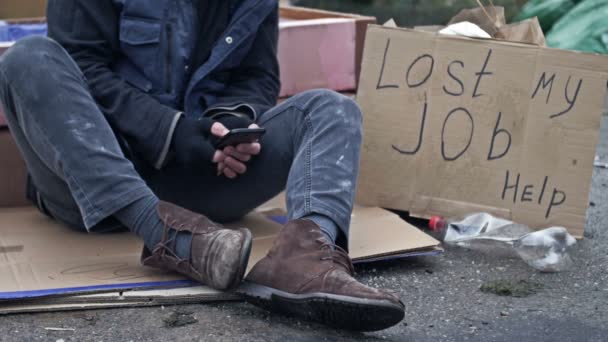 Dakloze Man Rillend Kou Met Een Mobiele Telefoon Zijn Handen — Stockvideo