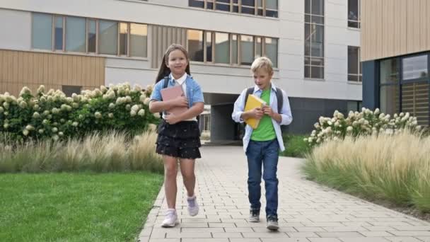 Dva Malí Spolužáci Chlapec Dívka Procházejí Školním Dvoře Dobré Náladě — Stock video