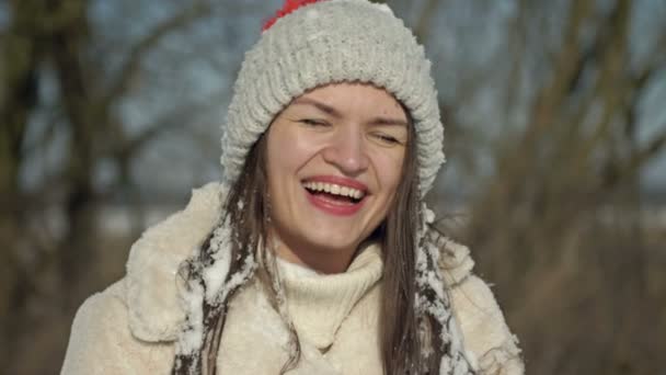 一个年轻的笑着的女人在雪球大战后被雪覆盖了 她对第一场雪和极好的冬季天气感到高兴 — 图库视频影像